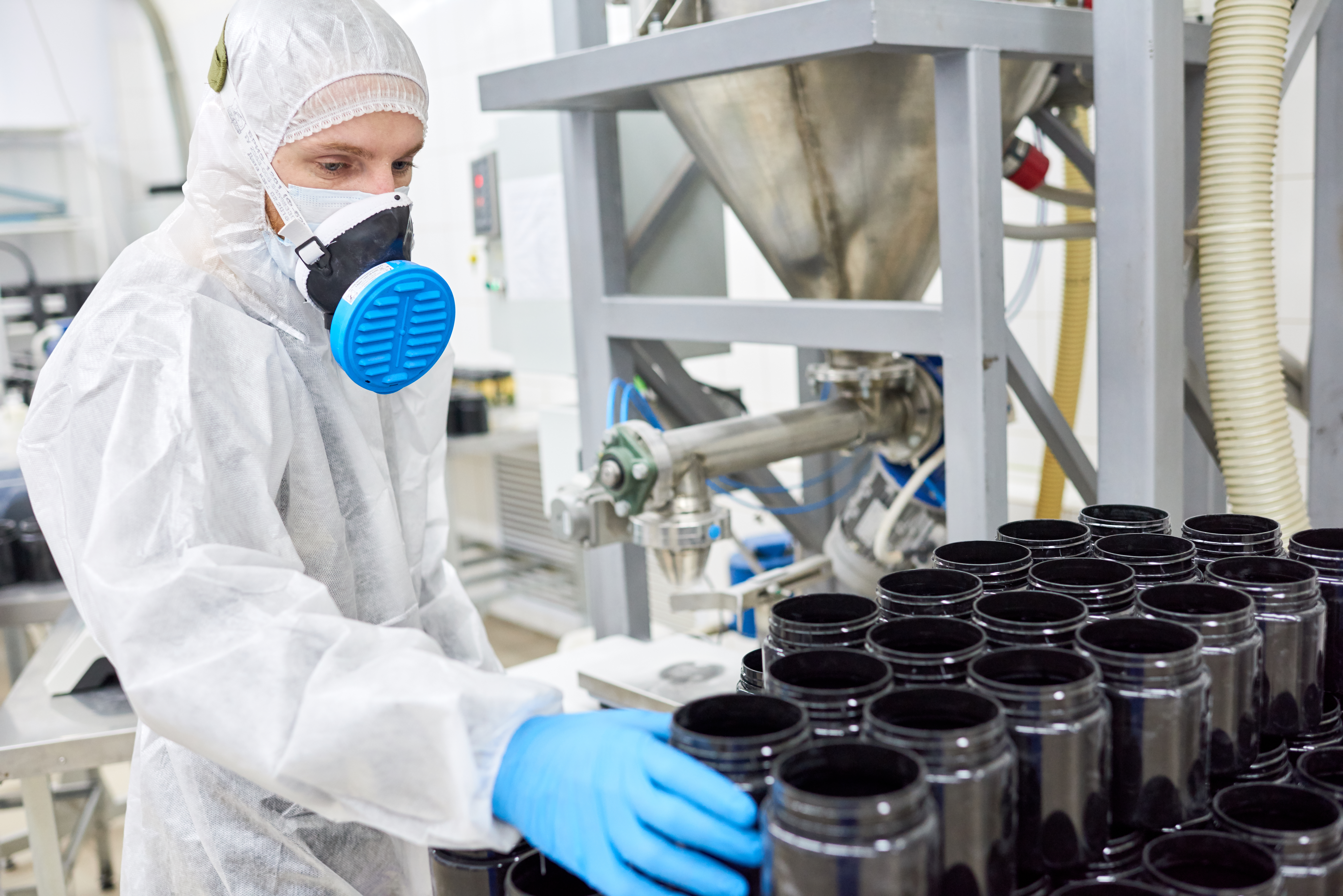 Factory employee working with protective equipment in sterile manufacturing environment